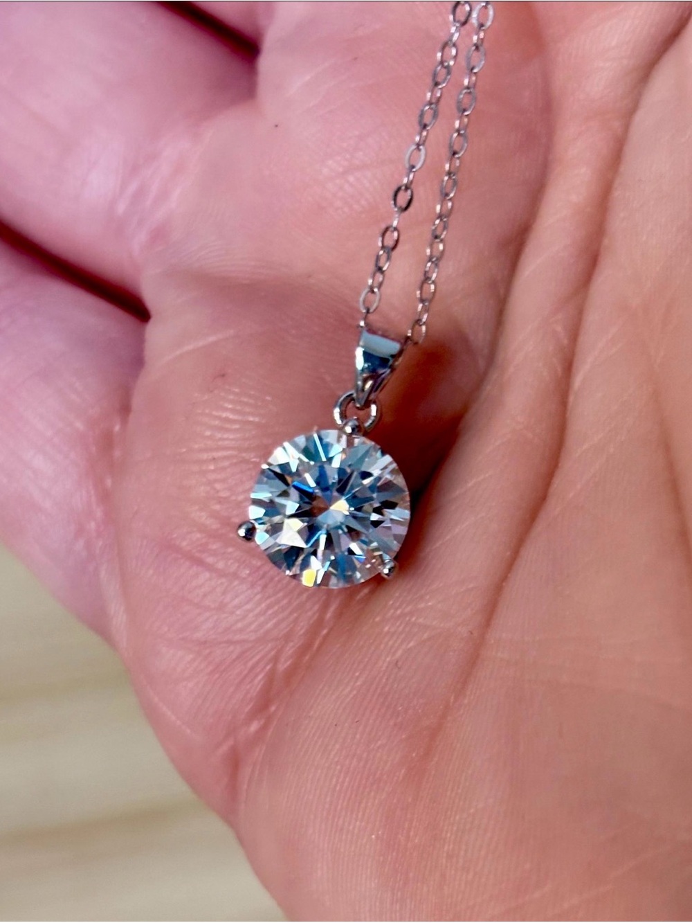A bright, white Moissanite solitaire in a minimalist 3-prong sterling setting!